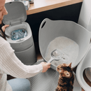 Imagen una mujer con su gato limpiando Litter Genie